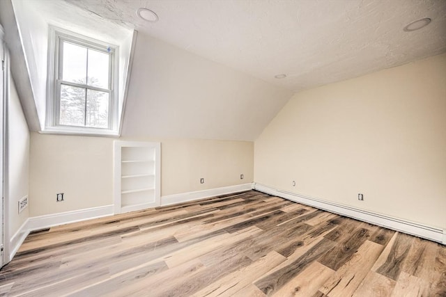 6 Nemasket St, Middleboro, MA 02346 - bonus room with a baseboard heating unit, baseboards, vaulted ceiling, built in features, and wood finished floors