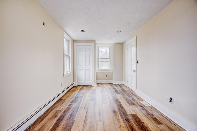 6 Nemasket St, Middleboro, MA 02346 - empty room with light wood-style flooring, a baseboard radiator, baseboards, and a textured ceiling