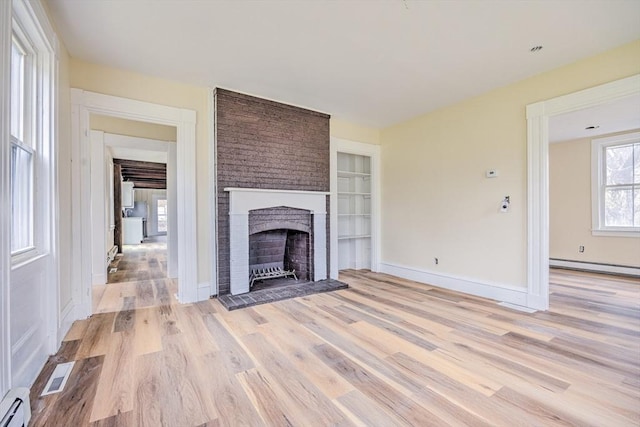 6 Nemasket St, Middleboro, MA 02346 - unfurnished living room featuring baseboard heating, a baseboard heating unit, visible vents, a brick fireplace, and light wood finished floors