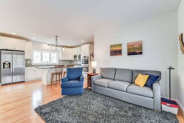 living room featuring sink and light hardwood / wood-style floors