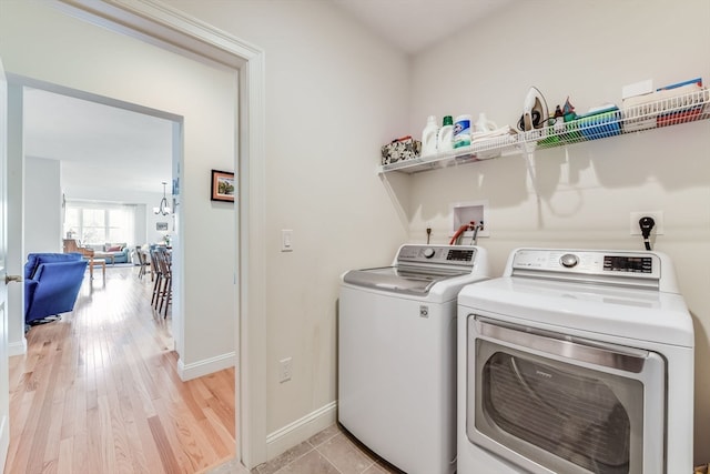 laundry room with independent washer and dryer and light hardwood / wood-style floors