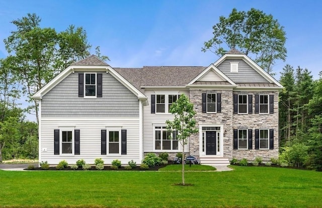 colonial home with stone siding, a standing seam roof, and a front yard