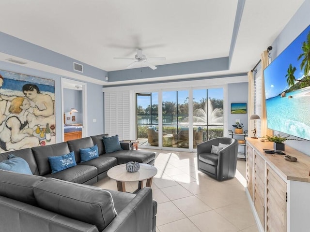 living room featuring light tile patterned floors, a raised ceiling, and ceiling fan