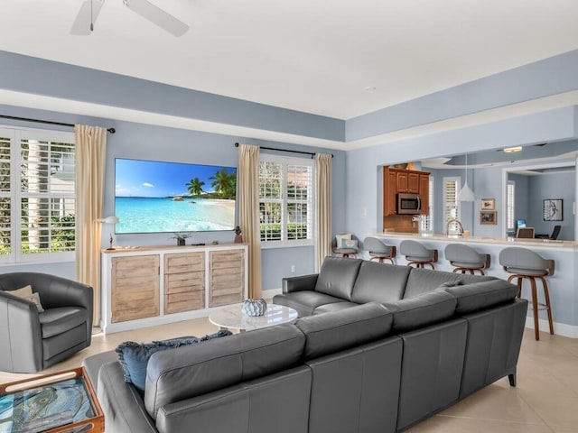 living room featuring ceiling fan, plenty of natural light, and light tile patterned flooring