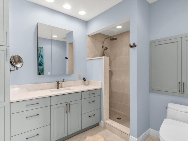 bathroom featuring tile patterned floors, vanity, toilet, and tiled shower