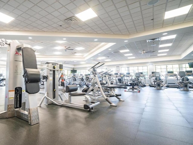 workout area with a paneled ceiling and ceiling fan