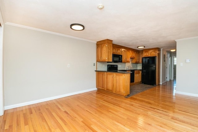 kitchen featuring decorative backsplash, ornamental molding, black appliances, and light hardwood / wood-style floors