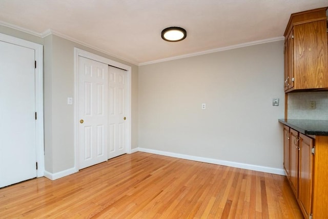 interior space featuring ornamental molding, backsplash, and light hardwood / wood-style flooring