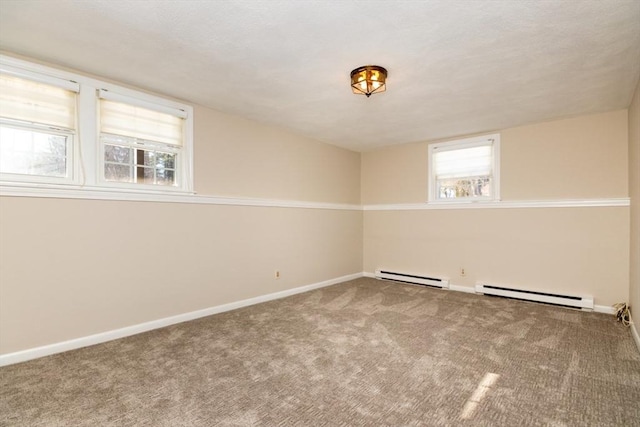 carpeted spare room with a baseboard heating unit