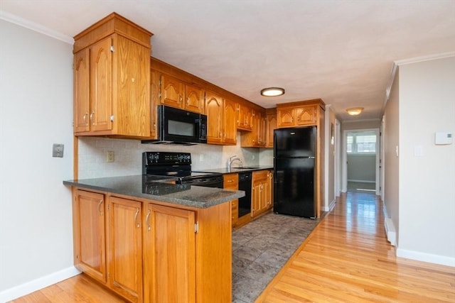 kitchen featuring black appliances, sink, decorative backsplash, ornamental molding, and kitchen peninsula