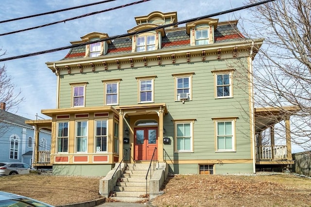 second empire-style home featuring cooling unit and mansard roof