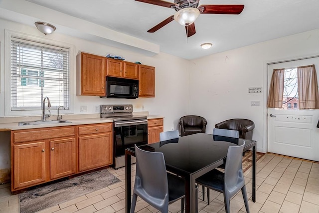 kitchen with electric range, a sink, black microwave, a healthy amount of sunlight, and ceiling fan