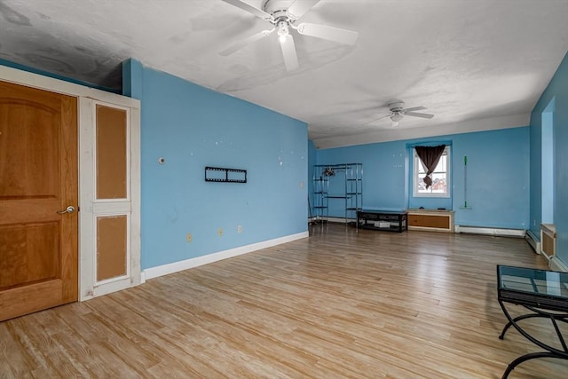 unfurnished living room featuring baseboards, a ceiling fan, and wood finished floors