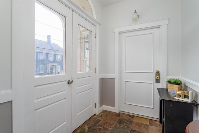 doorway to outside featuring french doors and stone finish floor