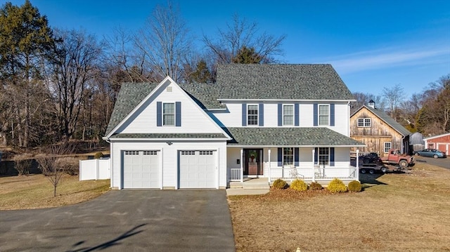 view of front of house featuring a porch, a garage, and a front yard