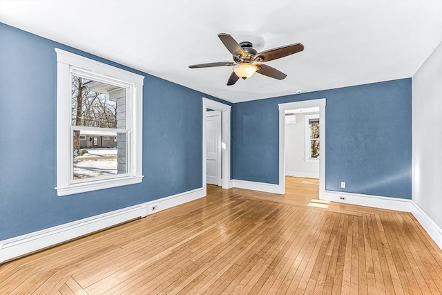 empty room with hardwood / wood-style flooring, a baseboard heating unit, and ceiling fan