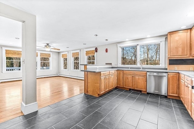 kitchen with hanging light fixtures, a healthy amount of sunlight, stainless steel dishwasher, and kitchen peninsula