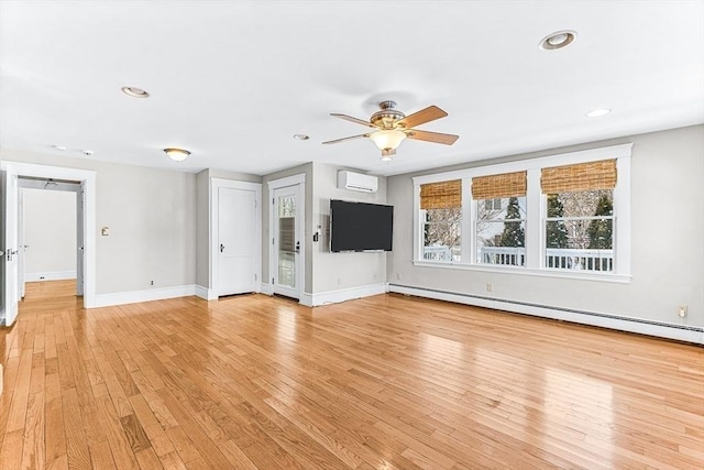 unfurnished living room featuring a baseboard radiator, ceiling fan, a wall unit AC, and light hardwood / wood-style flooring