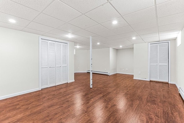 basement with dark hardwood / wood-style flooring and a baseboard radiator