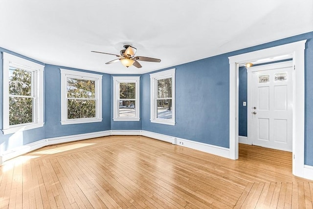 empty room with ceiling fan and light hardwood / wood-style floors