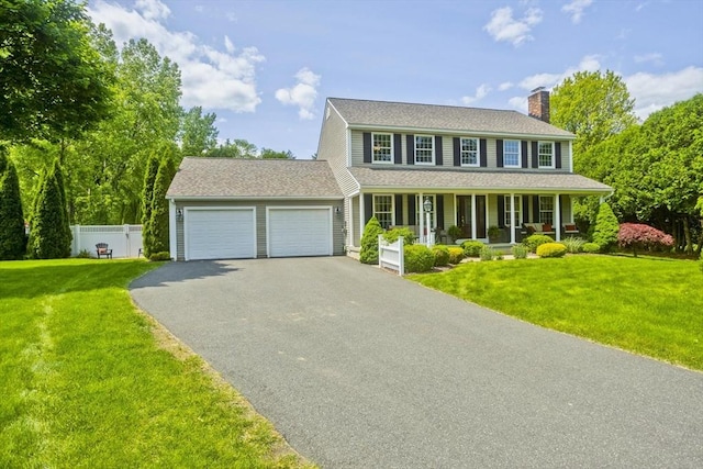 47 Avis Cir, Northampton, MA 01062 - colonial-style house featuring a porch, a chimney, asphalt driveway, an attached garage, and roof with shingles