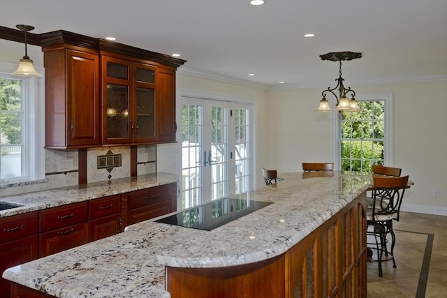 47 Avis Cir, Northampton, MA 01062 - kitchen featuring plenty of natural light, black electric stovetop, a kitchen breakfast bar, baseboards, and recessed lighting