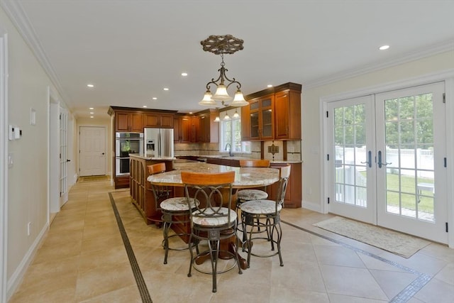 47 Avis Cir, Northampton, MA 01062 - kitchen with stainless steel appliances, inlaid floor details, a center island, brown cabinetry, and recessed lighting