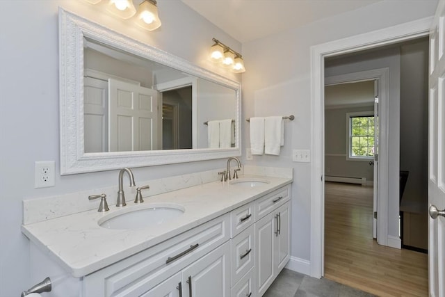 47 Avis Cir, Northampton, MA 01062 - bathroom with double vanity, a baseboard radiator, baseboards, and wood finished floors