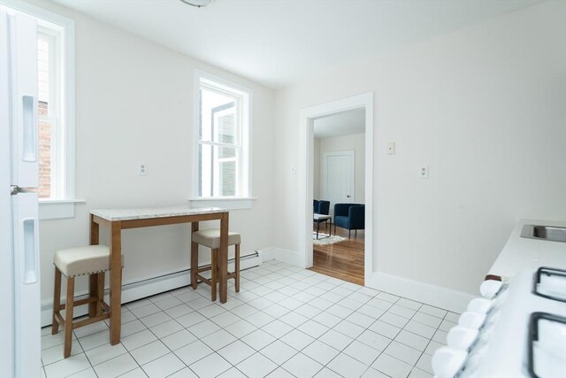 laundry area featuring healthy amount of natural light, light tile patterned floors, and baseboards