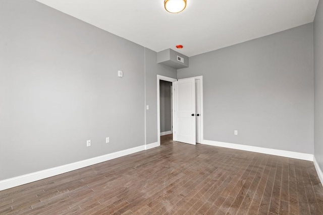 empty room with baseboards and wood finished floors