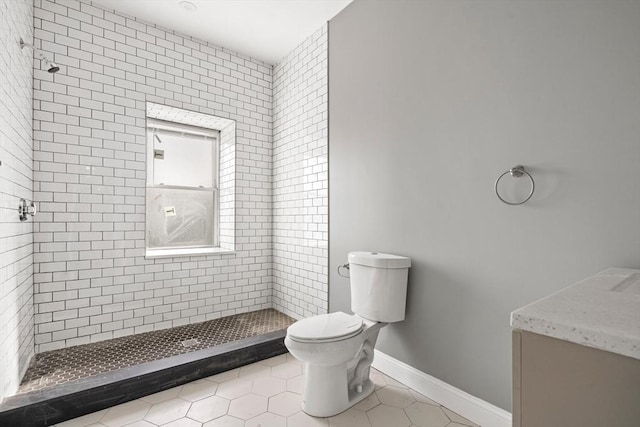 bathroom with toilet, tile patterned flooring, a stall shower, and vanity