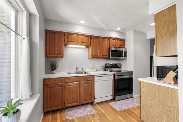 1702 Lewis O Gray Dr Unit 1702, Saugus, MA 01906 - kitchen with appliances with stainless steel finishes, light wood-style floors, light countertops, recessed lighting, and brown cabinetry
