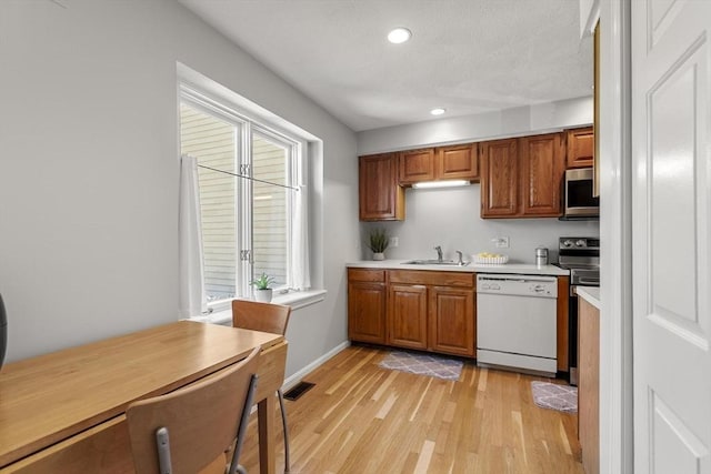 1702 Lewis O Gray Dr Unit 1702, Saugus, MA 01906 - kitchen featuring stainless steel appliances, light countertops, recessed lighting, light wood-style floors, and brown cabinetry