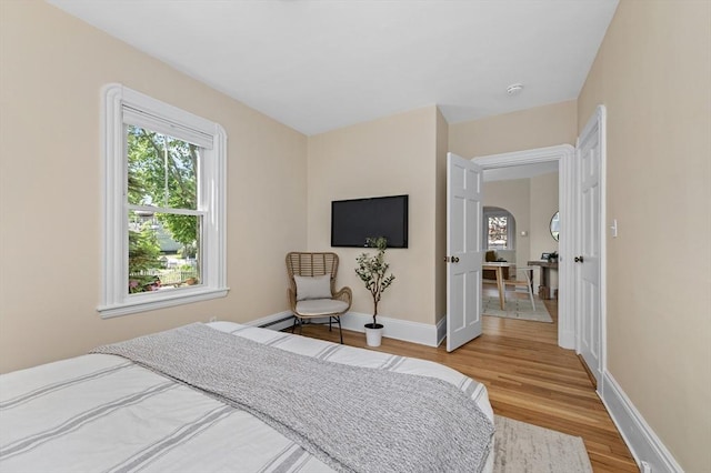 85 Holworthy Unit 85, Cambridge, MA 02138 - bedroom featuring wood finished floors, multiple windows, arched walkways, and baseboard heating