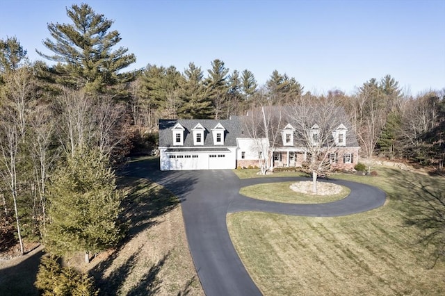 cape cod house with a garage and a front lawn