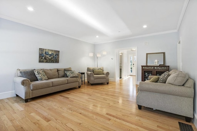 living room with light hardwood / wood-style floors and crown molding