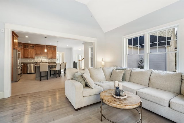 living room with lofted ceiling and light hardwood / wood-style flooring