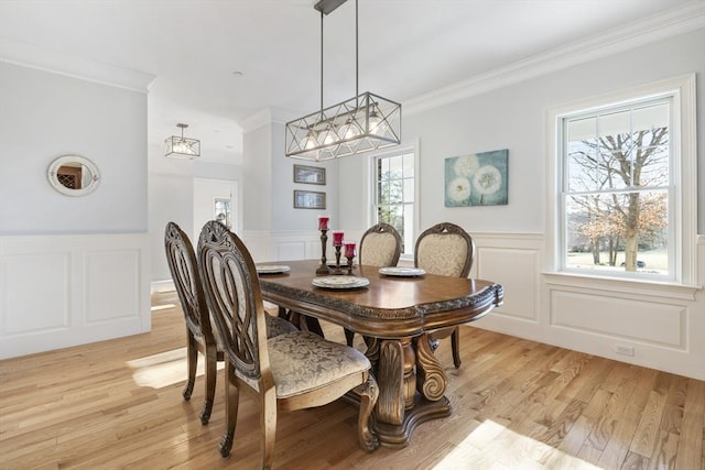 dining room featuring light wood-type flooring and ornamental molding