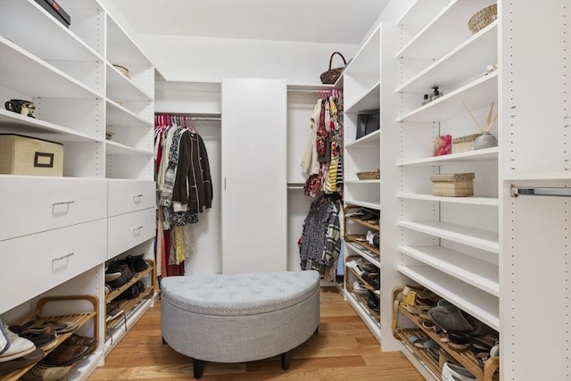 walk in closet with light hardwood / wood-style floors