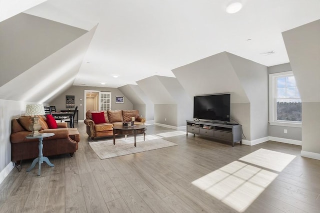 living room featuring light wood-type flooring and vaulted ceiling