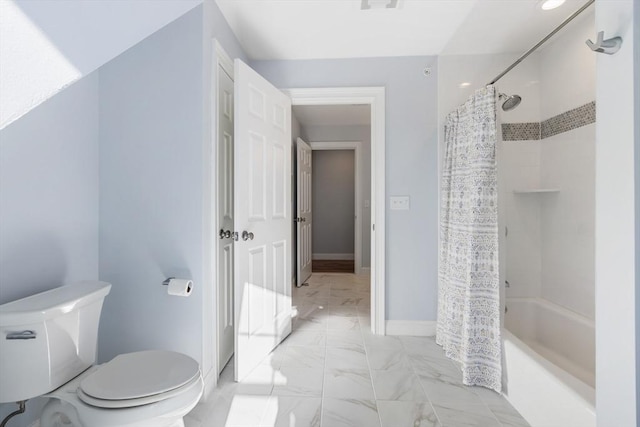 bathroom with toilet and shower / bath combo with shower curtain