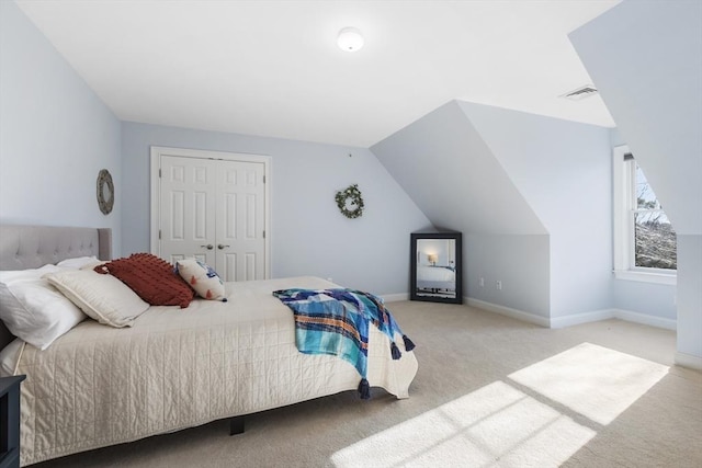 carpeted bedroom featuring vaulted ceiling and a closet