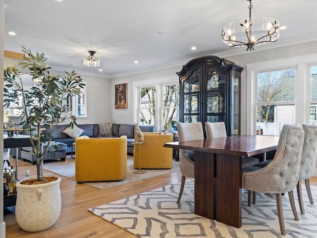 dining room with crown molding, a notable chandelier, and light hardwood / wood-style flooring