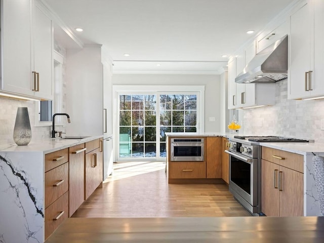 kitchen featuring sink, crown molding, stainless steel appliances, white cabinets, and light wood-type flooring