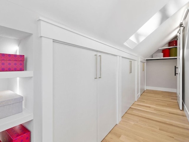 interior space with hardwood / wood-style floors and lofted ceiling with skylight