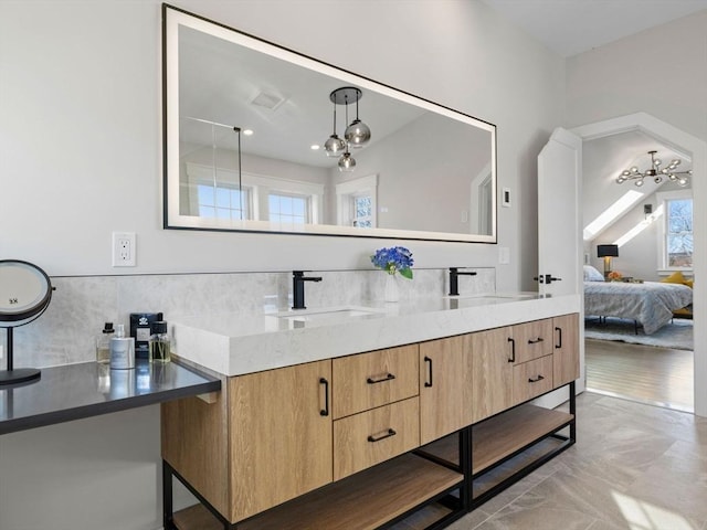 bathroom with vanity and a notable chandelier