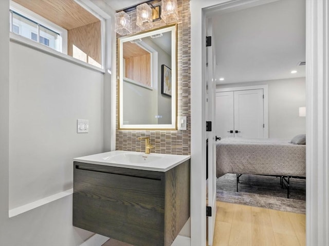 bathroom with vanity, backsplash, and hardwood / wood-style flooring