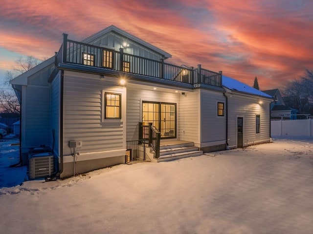 snow covered back of property with a balcony and central air condition unit