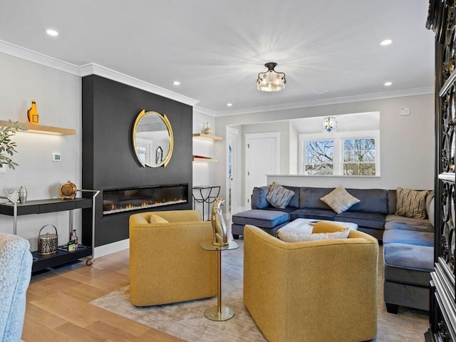 living room featuring a large fireplace, ornamental molding, and light hardwood / wood-style flooring