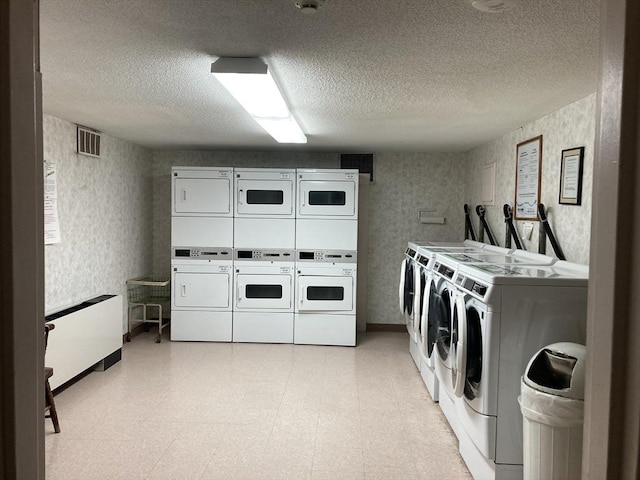 2 Summit Dr Unit 18, Reading, MA 01867 - communal laundry room with stacked washing machine and dryer, washer and clothes dryer, wallpapered walls, a textured ceiling, and baseboards